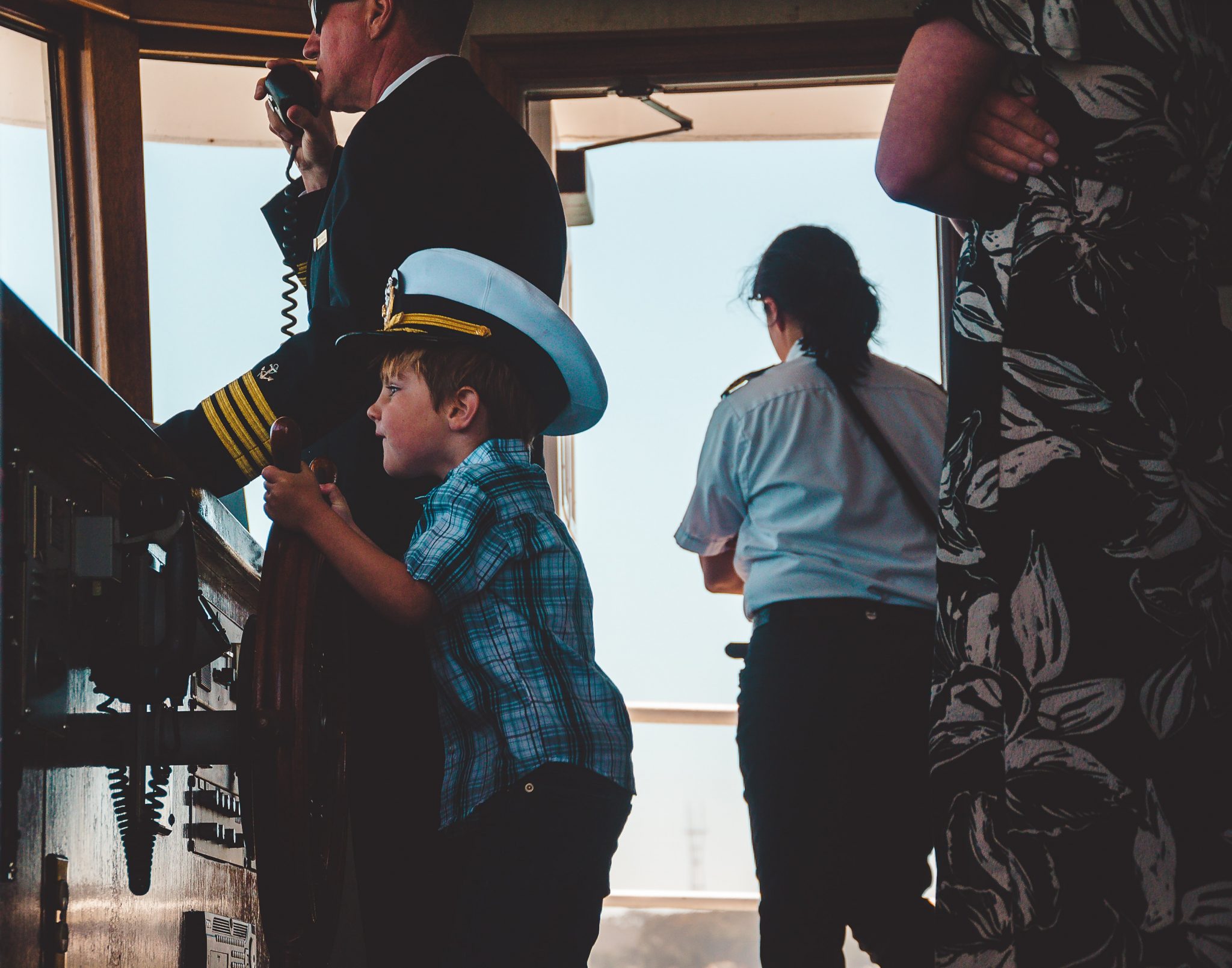boy in plaid top wearing ship captain hat