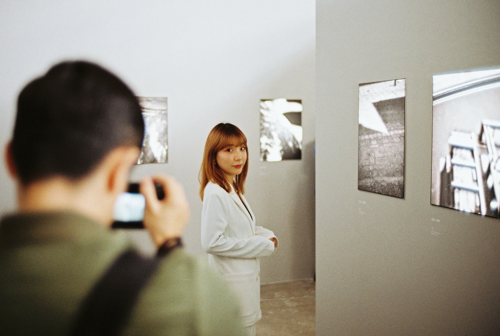 woman in white long sleeve shirt standing beside woman in gray long sleeve shirt
