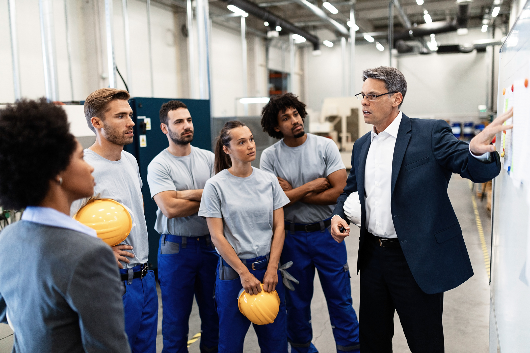 Manufacturing leader discussing organizational culture and performance with employees during an HR transformation initiative.